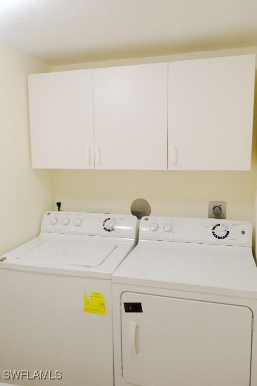 laundry room with washer and dryer and cabinets