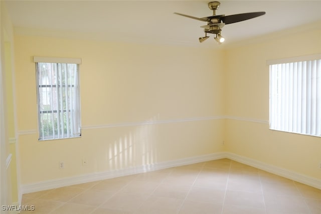 spare room with ceiling fan, light tile patterned flooring, and a wealth of natural light