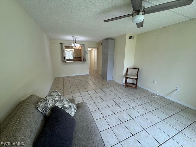 unfurnished living room featuring a textured ceiling, ceiling fan with notable chandelier, and light tile patterned floors