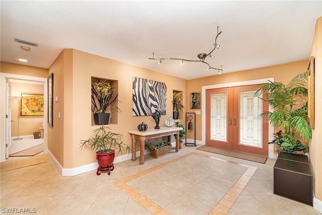 entryway featuring light tile floors, french doors, and rail lighting