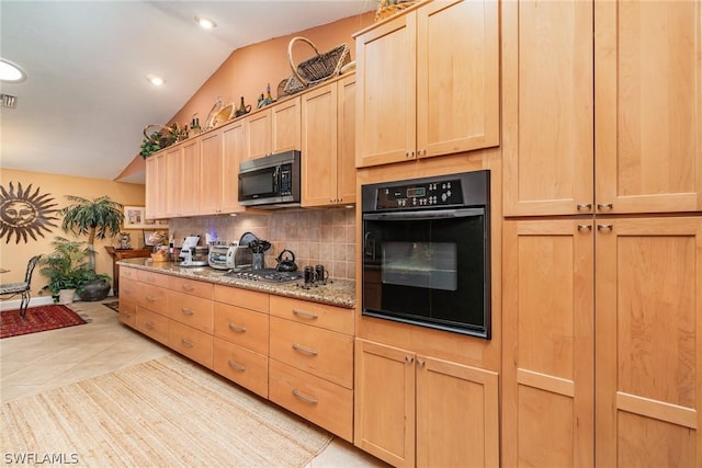 kitchen featuring vaulted ceiling, light brown cabinets, light stone countertops, oven, and backsplash