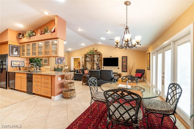 dining space with lofted ceiling, light tile patterned floors, sink, and a chandelier