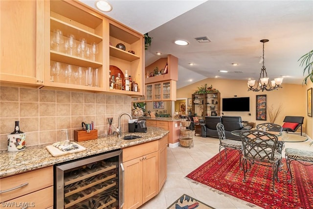 bar with sink, light tile patterned floors, wine cooler, vaulted ceiling, and light brown cabinets