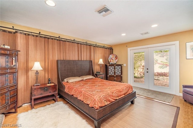 bedroom with hardwood / wood-style floors, access to exterior, and french doors