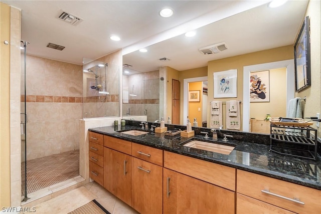 bathroom featuring tiled shower, tile patterned floors, and vanity