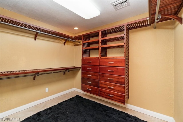 spacious closet with light tile patterned floors