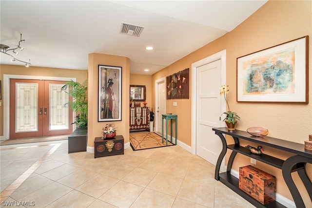 tiled entryway featuring french doors and rail lighting