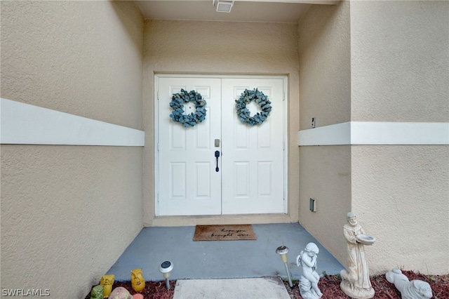 view of exterior entry featuring stucco siding