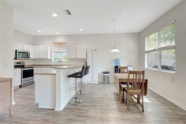 kitchen with stainless steel appliances, light countertops, a healthy amount of sunlight, and visible vents