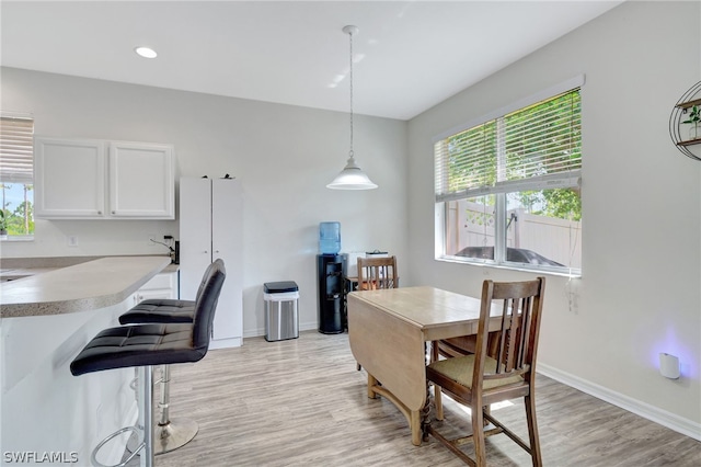 dining room with recessed lighting, baseboards, and light wood finished floors