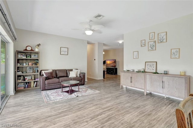 living room with light wood-type flooring and ceiling fan