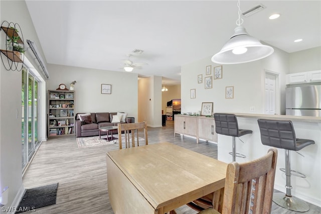 dining area with ceiling fan and light hardwood / wood-style flooring