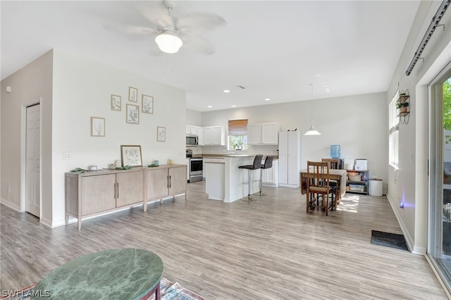 interior space with recessed lighting, baseboards, ceiling fan, and light wood finished floors