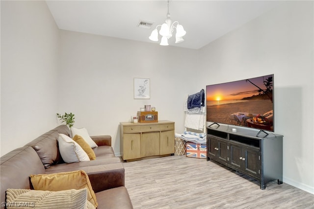 living area with light wood-type flooring, baseboards, visible vents, and a notable chandelier