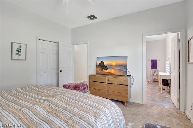 bedroom with light carpet, a closet, visible vents, and baseboards