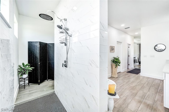 bathroom with visible vents, wood finished floors, tiled shower, and recessed lighting