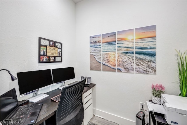 office space featuring baseboards and wood finished floors