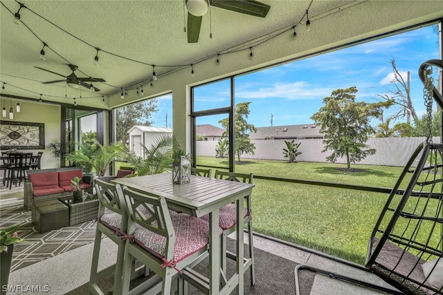 sunroom / solarium with rail lighting and ceiling fan