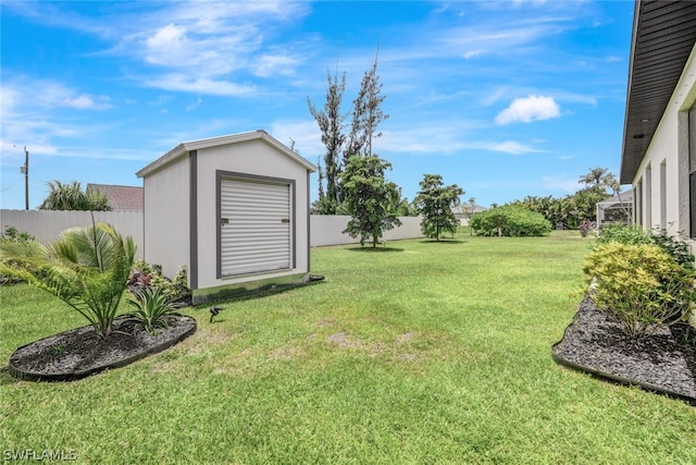 view of yard with a storage shed, a fenced backyard, and an outdoor structure