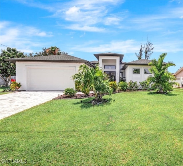 view of front of home with an attached garage, stucco siding, decorative driveway, and a front yard