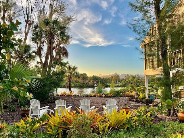 patio terrace at dusk featuring a water view and an outdoor fire pit