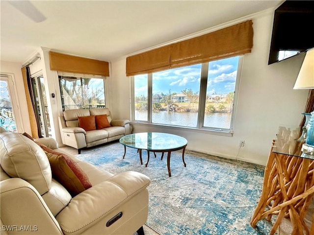 living room with a water view, carpet floors, and crown molding