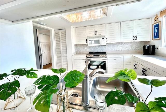 kitchen featuring decorative backsplash, white cabinetry, and electric stove