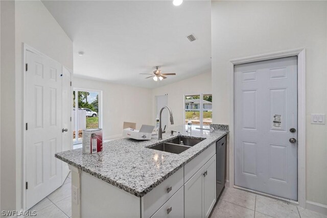 kitchen featuring light stone countertops, a wealth of natural light, sink, and ceiling fan