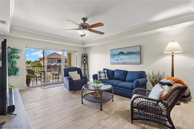 living room with a raised ceiling, ceiling fan, light hardwood / wood-style floors, and ornamental molding