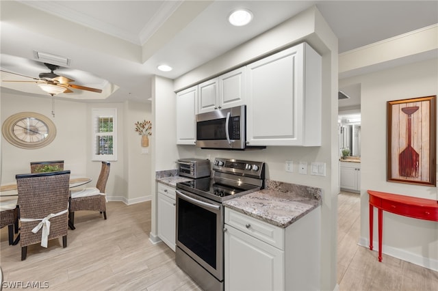 kitchen with stainless steel appliances, ceiling fan, crown molding, light hardwood / wood-style flooring, and white cabinets