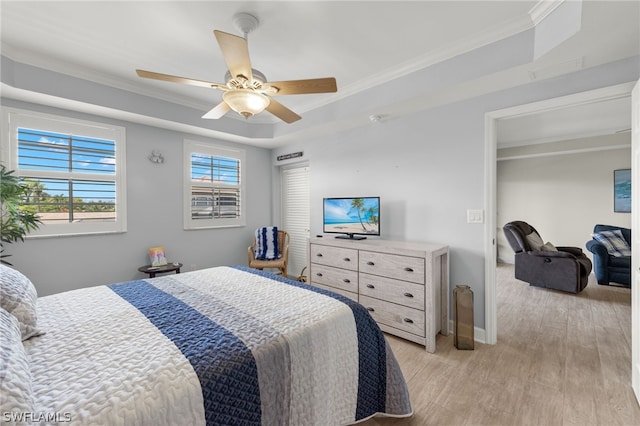 bedroom featuring ceiling fan, light hardwood / wood-style floors, a raised ceiling, and crown molding