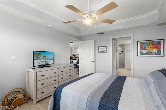 bedroom featuring ensuite bath, a raised ceiling, ceiling fan, and crown molding