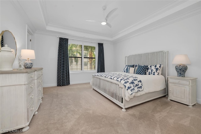 carpeted bedroom featuring ceiling fan, ornamental molding, and a raised ceiling