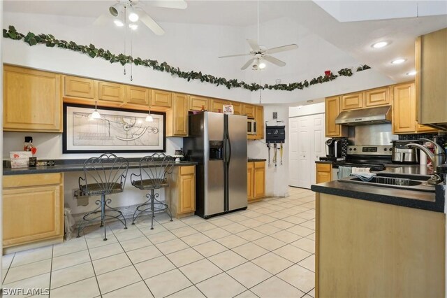 kitchen with a breakfast bar area, ceiling fan, lofted ceiling, and appliances with stainless steel finishes