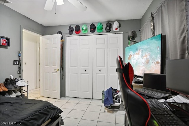 bedroom with ceiling fan, a closet, and light tile patterned floors