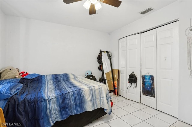 tiled bedroom featuring ceiling fan and a closet