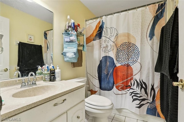 bathroom with tile patterned flooring, vanity, and toilet