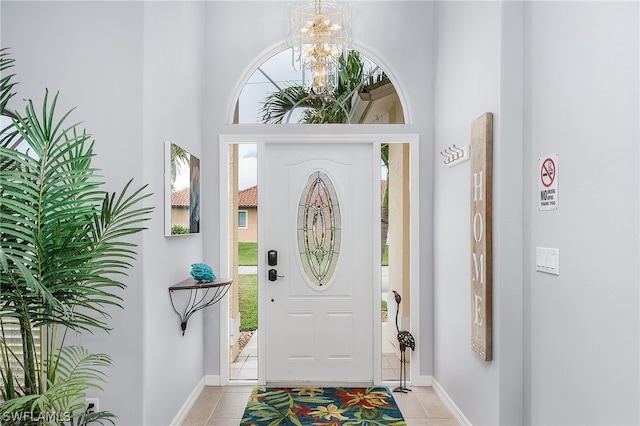 tiled foyer entrance with a notable chandelier