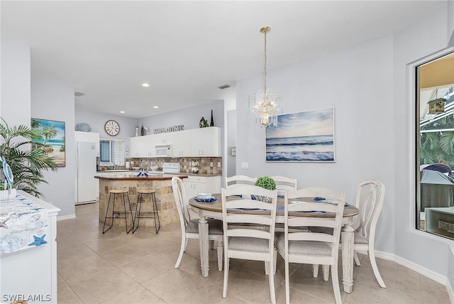 tiled dining space with a notable chandelier