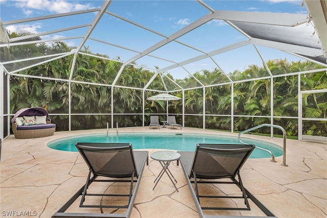 view of pool with glass enclosure and a patio area