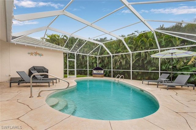 view of swimming pool with glass enclosure and a patio area