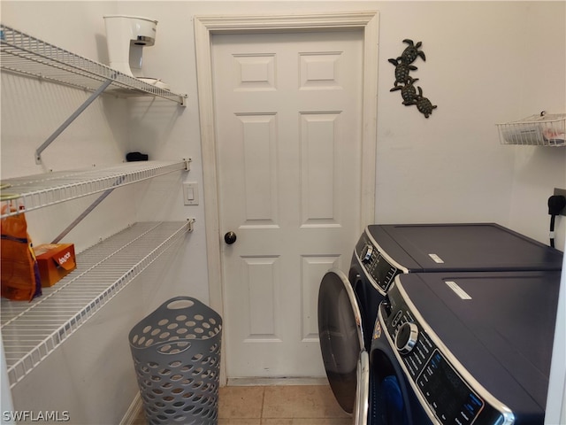 clothes washing area featuring light tile flooring and washing machine and clothes dryer