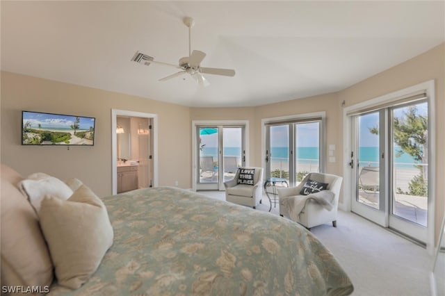 bedroom featuring access to outside, multiple windows, ceiling fan, and a water view