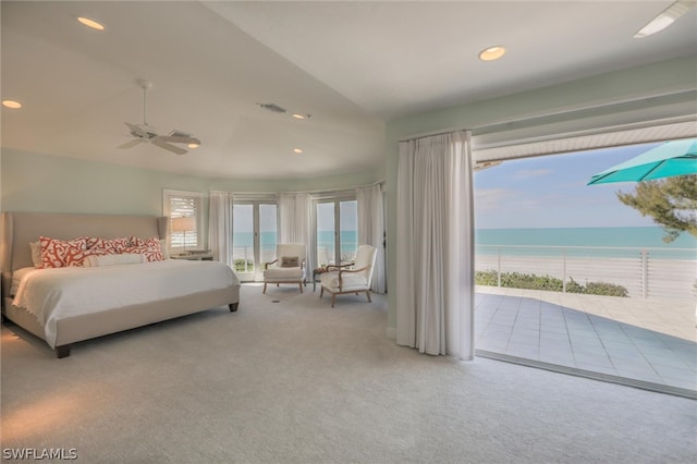 carpeted bedroom featuring access to exterior, ceiling fan, a water view, and a beach view