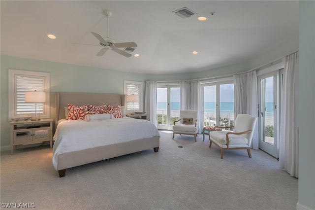 carpeted bedroom featuring access to exterior, ceiling fan, and a water view