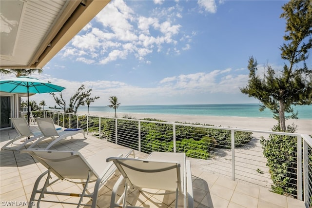 balcony featuring a water view and a beach view