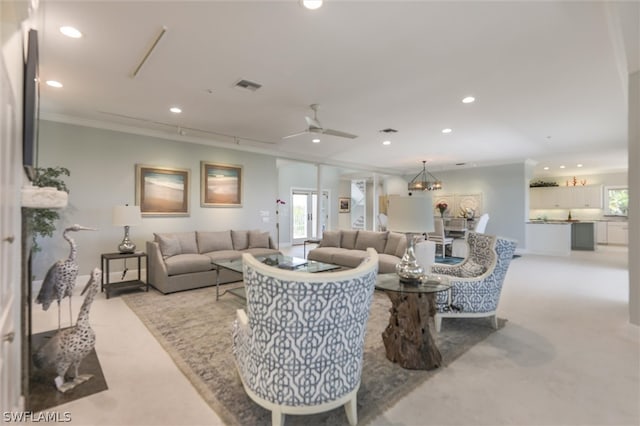 living room featuring ornamental molding, light colored carpet, ceiling fan, and a healthy amount of sunlight