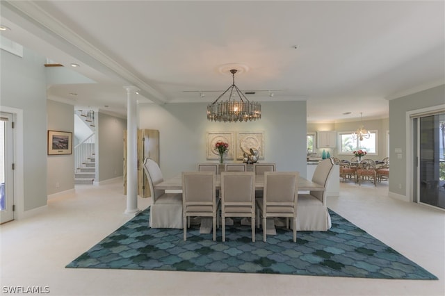 dining room featuring carpet flooring, a chandelier, decorative columns, and ornamental molding