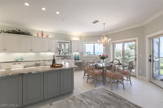 kitchen featuring white cabinets, a wealth of natural light, and light stone countertops