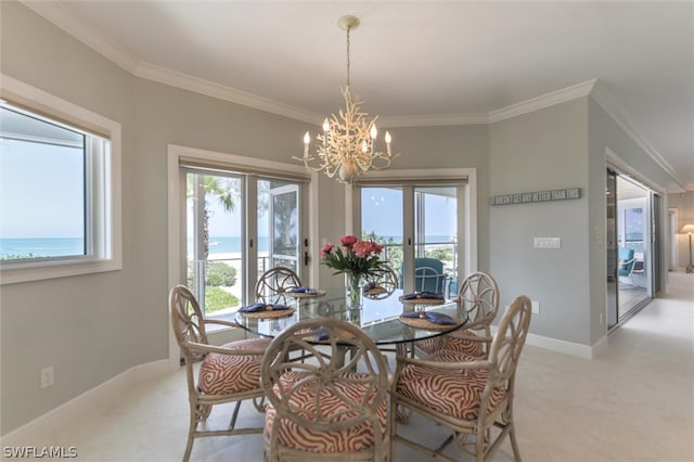 carpeted dining room featuring crown molding, french doors, a water view, and a chandelier